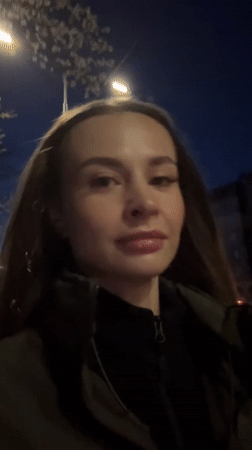 Woman walks through illuminated Kyiv streets at night