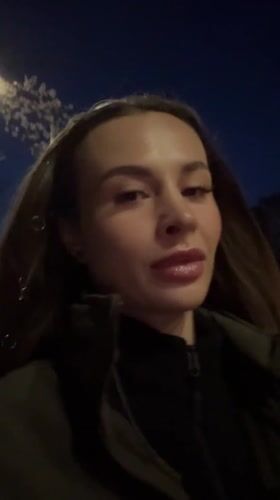 Woman walks through illuminated Kyiv streets at night