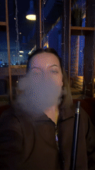 Woman enjoys hookah session at dimly lit Klin lounge