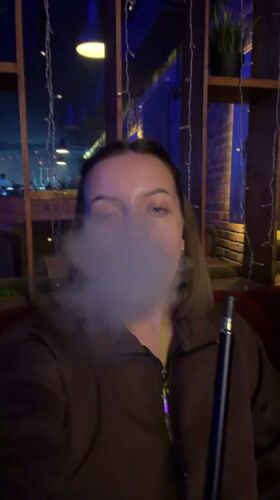 Woman enjoys hookah session at dimly lit Klin lounge