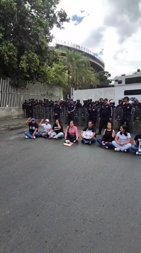 Small group stages sit-down protest facing riot police in Caracas