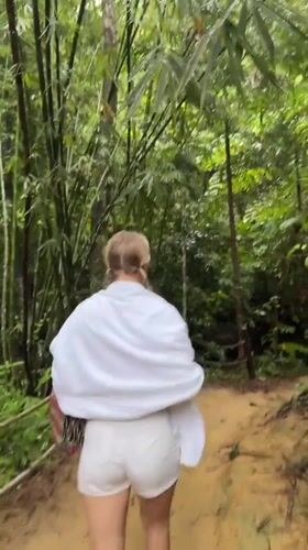 Woman walks forest path in Ban Pa Tee, Thailand