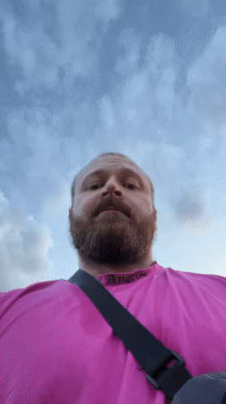 Man in pink shirt photographed on rural road in Russia