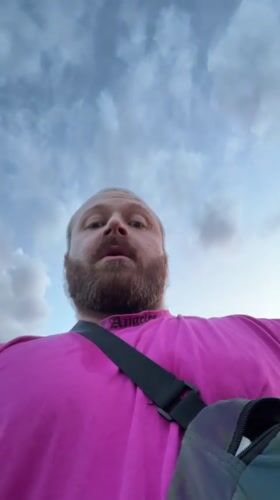 Man in pink shirt photographed on rural road in Russia