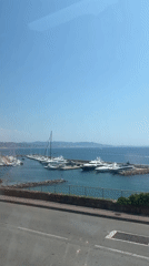 Calm day at Cannes harbor, yachts docked under clear skies.
