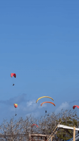 Colorful paragliders swarm the skies above Kuta Selatan