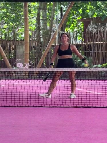 Women play racket sport on pink court in General Luna