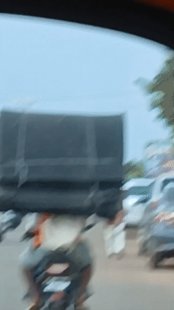 Motorcyclist carries oversized black object through Rido, Nigeria