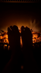 Novokuznetsk resident warms feet by electric fireplace on Sunday evening