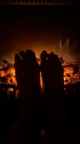 Novokuznetsk resident warms feet by electric fireplace on Sunday evening