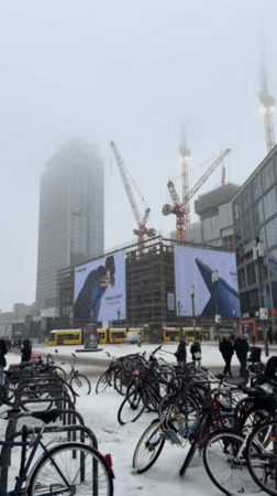 Woman documents snowy day at Berlin shopping center