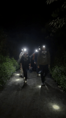 Group conducts nighttime walk along vegetation-lined path in Indonesia