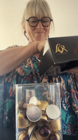 Woman organizes coffee pods into storage container in Chambœuf