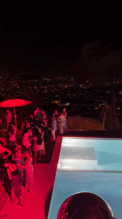 Red-lit poolside party crowd in Cannes at night