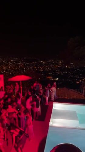 Red-lit poolside party crowd in Cannes at night