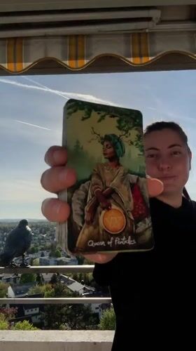 Woman displays tarot card from balcony in Waiblingen