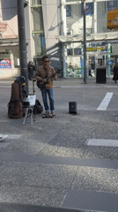 Street musician performs electric guitar near Vancouver's Pacific Centre