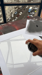Person spray-paints acrylic sheet in Krasnoyarsk workshop