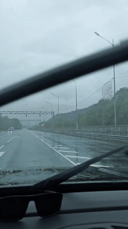 Gray train passes through rainy Adlerskiy, Russia