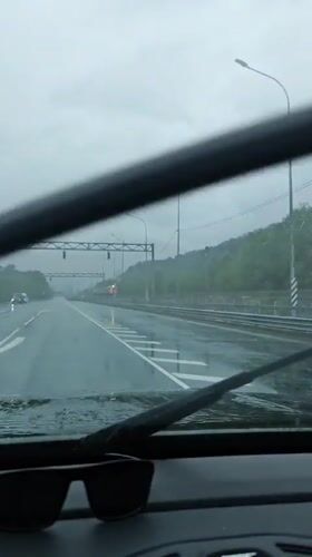 Gray train passes through rainy Adlerskiy, Russia