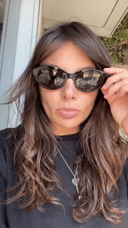 Woman removes sunglasses in Tel Aviv