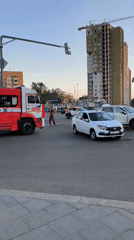 Man stands in Moscow intersection with emergency vehicles present
