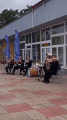 Brass band plays outside while pigeons gather nearby