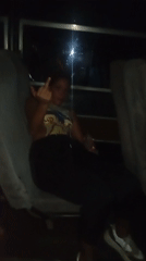 Woman poses, gestures for camera on late-night bus in Venezuela