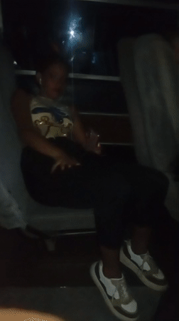 Woman poses, gestures for camera on late-night bus in Venezuela