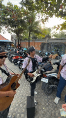 Street musicians perform as tourist enjoys seafood in Kuta