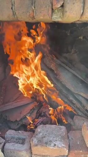 Wood fire burns in brick structure in Perushtitsa, Bulgaria