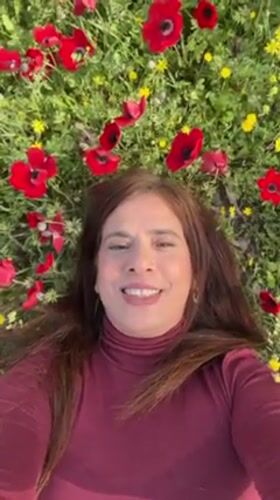 Woman rests in poppy field near Kibbutz Ruhama