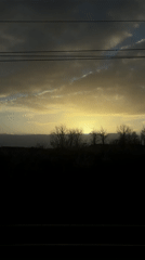 Train passenger films dramatic sunset through window near Woodwalton