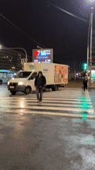 Woman with colorful umbrella navigates rainy Saint Petersburg streets