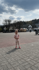 Toddler plays in strawberry pajamas at Wisła town square