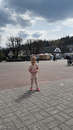 Toddler plays in strawberry pajamas at Wisła town square