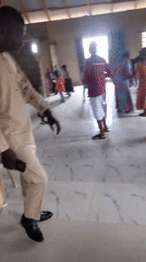Community gathering in hall with dancing and worship activities