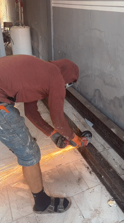 Angle grinder cutting metal beams in Roubaix, sparks flying