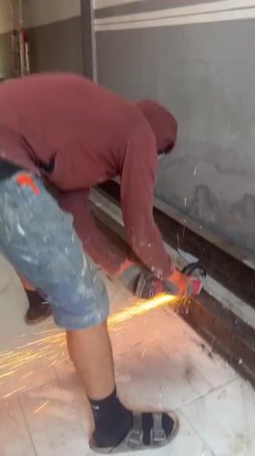 Angle grinder cutting metal beams in Roubaix, sparks flying