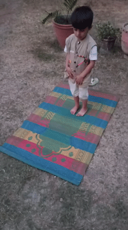 Young boy performs outdoor prayer in Pakistan backyard