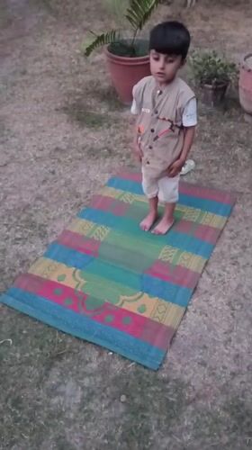 Young boy performs outdoor prayer in Pakistan backyard