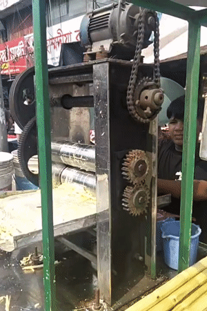 Man operates sugarcane juice machine in Dhaka