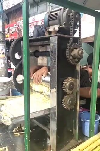 Man operates sugarcane juice machine in Dhaka