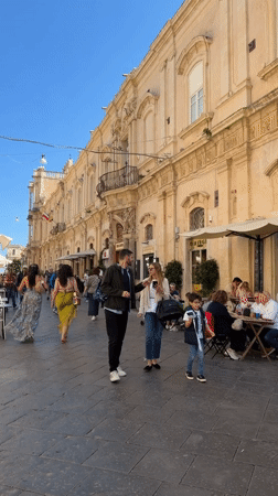 Tourist activities documented in baroque Noto, Italy during midday