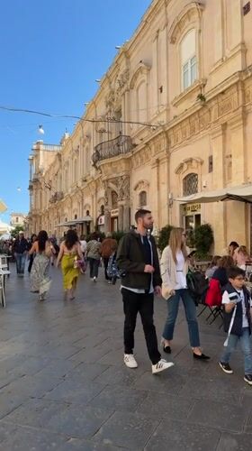 Tourist activities documented in baroque Noto, Italy during midday
