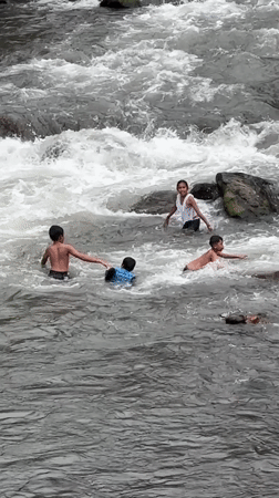 Children play in rocky rapids, Klungkung river, Indonesia