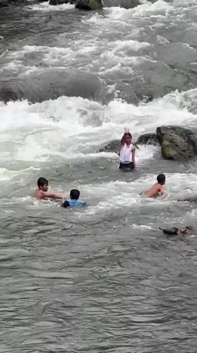 Children play in rocky rapids, Klungkung river, Indonesia