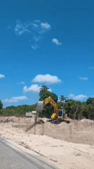 Excavator digging through sandy construction site in Ko Samui