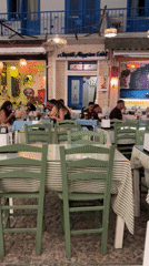 Busy outdoor restaurant terrace on a European cobblestone street at night