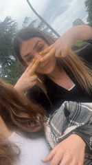 Young women apply yellow paint during riverside photo session